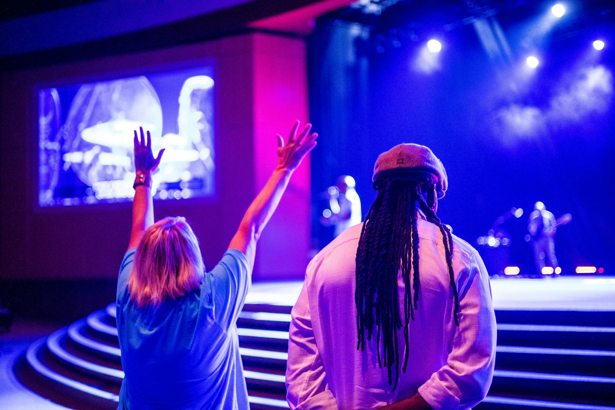 Fans enjoying a live concert with vibrant stage lighting and performers.